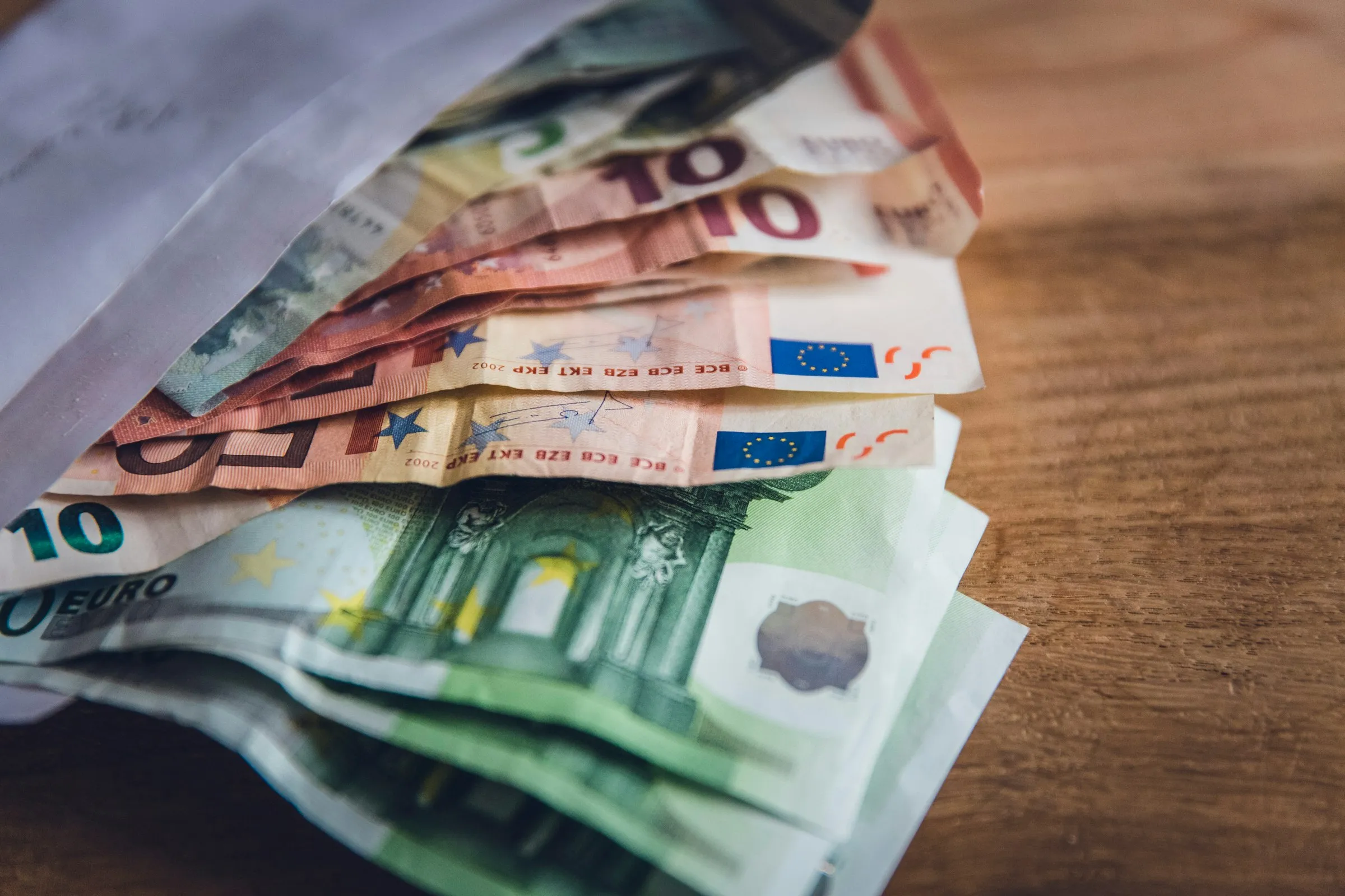 Eiro banknotes uz koka galda