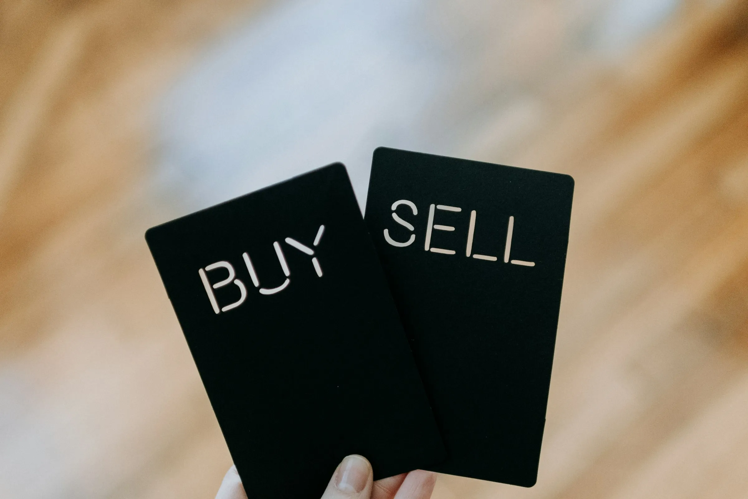 Roka tur kartītes ar uzrakstiem BUY un SELL